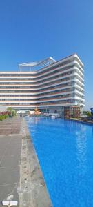 秾莎Two Bedroom Apartment at The Nove, Nuvasa Bay, Nongsa 719的一座大型建筑,前面设有一个大型游泳池