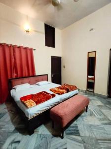 Ayodhya2 Bedroom Suite on Ground Floor Ayodhya的一间卧室配有一张床、一把椅子和红色窗帘