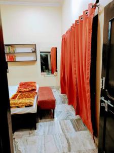 Ayodhya2 Bedroom Suite on Ground Floor Ayodhya的一间卧室配有橙色窗帘,卧室内配有一张床