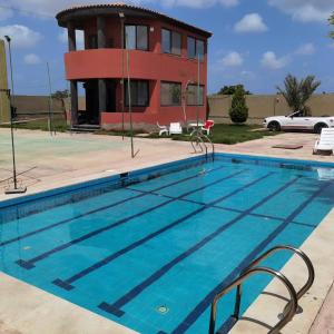 伯格埃拉伯Villa Mostafa Sadek, Swimming pool, Tennis & Squash - Borg ElArab Airport Alexandria的房屋前的游泳池