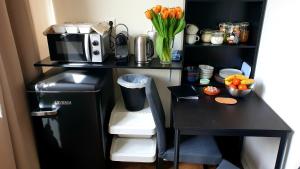 阿姆斯特丹Amor Guesthouse的一张黑色的办公桌,配备了微波炉和冰箱