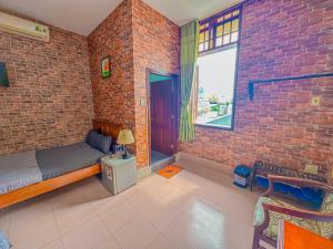 芹苴Hoàng Sơn's Home的卧室设有砖墙、一张床和一个窗户