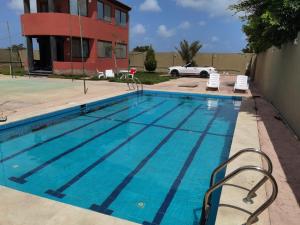 伯格埃拉伯Villa Mostafa Sadek, Swimming pool, Tennis & Squash - Borg ElArab Airport Alexandria的大楼前的游泳池