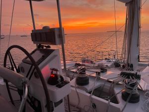 Isla Wichitupo Grande"Marea" Sunreef 62 Catamaran with Crew all inclusive的海上的船,背面有日落