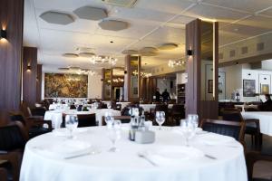 克鲁舍沃蒙大拿宫酒店的一间设有白色桌椅的用餐室