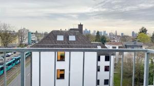美因河畔法兰克福Living in a penthouse in Frankfurt, with balcony for smokers的一座白色的建筑,有屋顶,有城市背景
