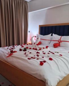 纳祖尔Hotel Residence Ramsis的一张有红玫瑰花瓣的床,上面有婚礼登记员