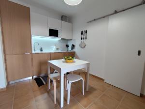 莫托拉Vila Nova Guest House的厨房配有一张白色的桌子和两张凳子