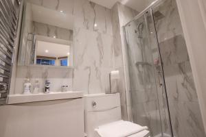 伦敦The Avonmore Olympia的带淋浴、卫生间和盥洗盆的浴室