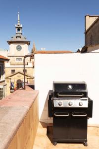 奥维多Green Hostel Oviedo的屋顶上的烧烤架,钟楼
