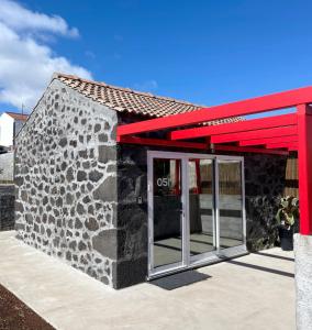 圣罗克杜皮库Aires Hostel的一座石头建筑,有红色的屋顶和门
