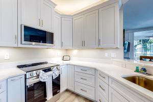 那不勒斯Luxury Condo in Regatta的白色的厨房配有白色橱柜和水槽