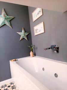 戈斯兰Englefield Guesthouse的墙上的星星浴室设有浴缸