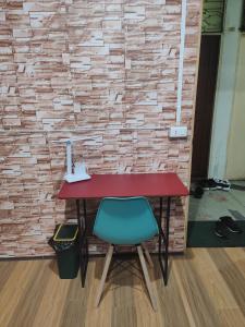 曼谷108 Quiet and Cozy apartment w/free Wi-Fi的砖墙旁的一张桌子和一张绿色椅子