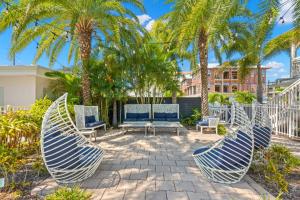 克利尔沃特Hotel Cabana Clearwater Beach的一个带两把椅子的庭院,棕榈树