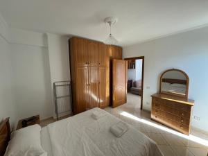 萨兰达Comfort Apartments Promenade的一间卧室配有一张床、梳妆台和镜子