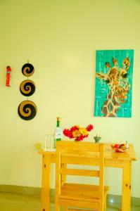 RuhengeriKarisimbi Cave Resort的一张木桌,墙上挂着长颈鹿的照片