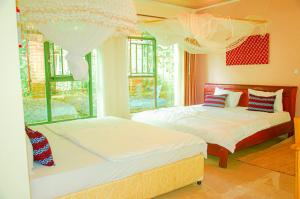 RuhengeriKarisimbi Cave Resort的带2扇窗户的客房内的2张床