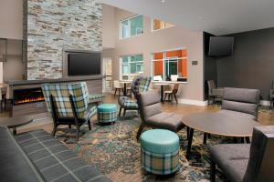 洛迪Residence Inn by Marriott Lodi Stockton的客厅设有壁炉、椅子和桌子