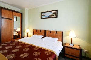 乌兰巴托纳兰图尔酒店的酒店客房设有一张大床和两盏灯。