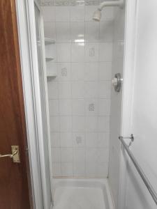 班多伦Fairy Bridge Lodge的带淋浴的浴室和白色瓷砖墙