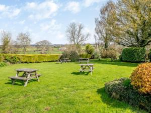韦尔斯The Burcott Inn Cottages的草地上设有野餐桌的公园
