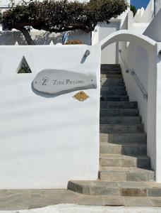 圣斯特凡诺斯Zisis Pension的建筑物一侧有标志的楼梯