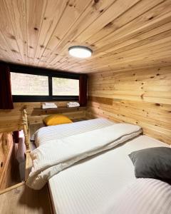 里泽Nayon Tiny House的木镶板客房内的两张床
