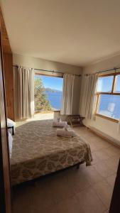 圣卡洛斯-德巴里洛切加维塔斯山林小屋的一间卧室设有一张床,享有海景