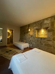 阿拉恰特MaSaLa Otel的一间卧室设有两张床和石墙