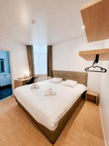 奥斯坦德阿尔法酒店的一间卧室配有一张带白色床单的大床