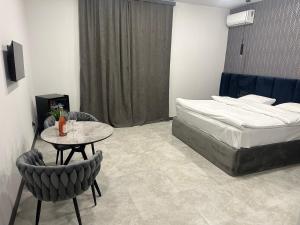 PʼarakʼarLux Plaza (New Rooms)的卧室配有一张床和一张桌子及椅子