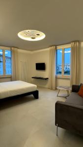阿雷佐Sette Note Guest House的一间卧室配有一张床、一张沙发和一台电视。