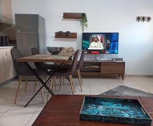 萨莫色雷斯Vaikouzis Houses的一间带桌子和电视的客厅以及一间厨房。