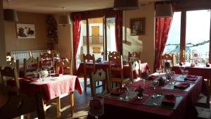 圣费朗索瓦-隆尚莱布赛久酒店的一间带桌椅和红色桌布的用餐室