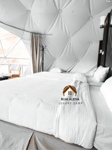 瓦迪拉姆RUM ALIENA LUXURY CAMP的卧室配有白色的床,上面有标志