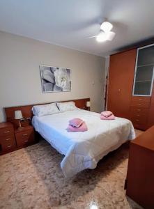 塔拉戈纳Chalet con piscina privada y barbacoa的一间卧室配有一张床,上面有两条粉红色的毛巾