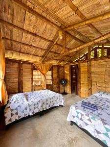 UticaCabañas Los Pomarrosos的一间卧室设有两张床和木制天花板