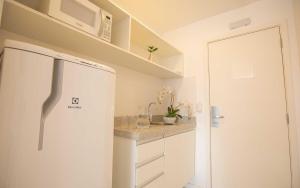 巴西利亚Vision Diária Brasil 06908的厨房配有白色冰箱和微波炉