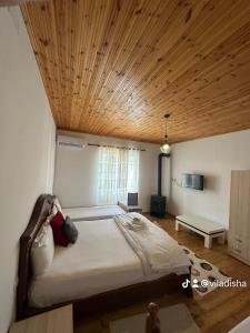 地拉那VILA DISHA的一间卧室设有一张带木制天花板的大床