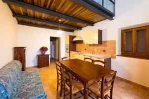 阿夸拉尼亚Casetta in Pietra的厨房以及带木桌和椅子的用餐室。