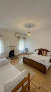 地拉那VILA DISHA的一间卧室设有两张床和一个壁炉