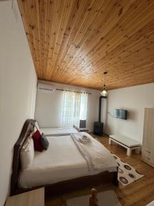 地拉那VILA DISHA的一间卧室设有一张带木制天花板的大床