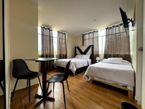 卡哈马卡Las Condes II的一间卧室配有两张床和一张桌子及椅子