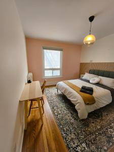 渥太华Ottawa Downtown Cozy Guesthouse的一间卧室配有一张床、一张桌子和一个窗户。
