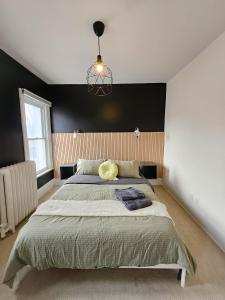 渥太华Ottawa Downtown Cozy Guesthouse的一间卧室设有一张大床和黑色的墙壁