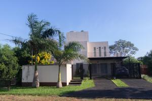 恩卡纳西翁Habitación con amplia terraza en Encarnacion的前面有棕榈树的房子