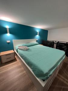 马里利亚诺Da Lello: Luxury Loft strategico的一间卧室设有一张蓝色墙壁的大床
