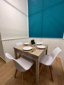 马里利亚诺Da Lello: Luxury Loft strategico的一张带白色椅子的木桌和蓝色的墙壁