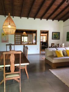 加罗帕巴Casa na Barra ampla e arejada com jardim incrível的客厅配有桌子和沙发